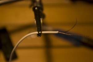 burnt The prepared wire. It's difficult to see, but if you look closely, you can make out the slightly different metalic look near the end. That's lightly-soot-covered but uninsulated wire. Solder, with a little coaxing, will stick to this.
